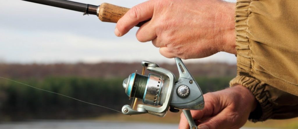 A man using a spincast reel while fishing