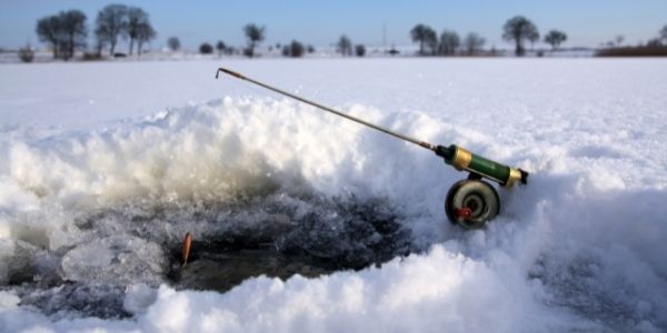 image of a fishing rod near an ice fishing hole