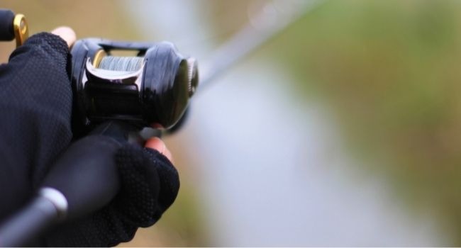 Image of a person holding the baitcasting reel